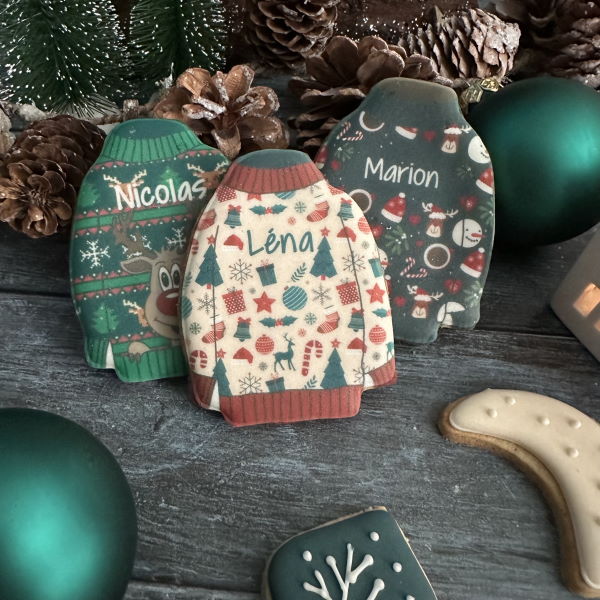 Biscuits personnalisés en forme de pulls moches de Noël avec prénoms, faits main en France. Cadeaux gourmands et festifs.