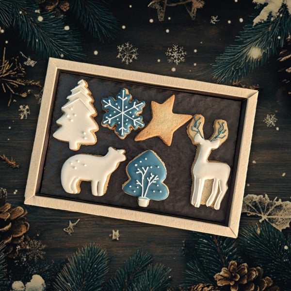 Boîte de biscuits artisanaux de Noël personnalisables 'Northern Light' aux motifs givrés et hivernaux, réalisés à la main, présentés dans un coffret élégant avec des décorations en glaçage blanc et doré