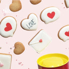 Assortiment de biscuits artisanaux de la Love Box : 3 bulles, 3 enveloppes, 3 cœurs glacés et 6 petits cœurs non glacés. Des créations sucrées parfaites pour la Saint Valentin