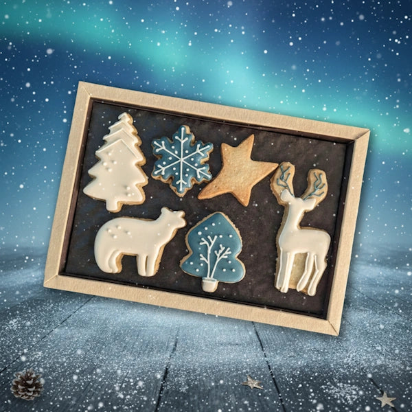 Boîte de biscuits artisanaux de Noël personnalisables 'Northern Light' aux motifs givrés et hivernaux, réalisés à la main, présentés dans un coffret élégant avec des décorations en glaçage blanc et doré
